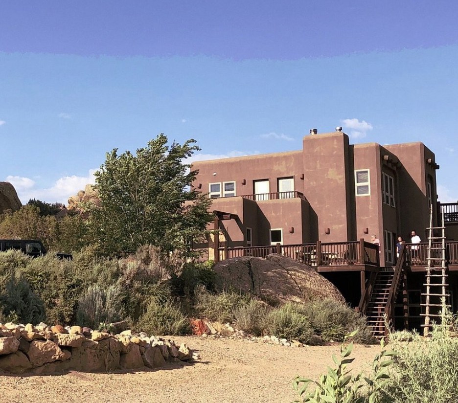 A southwestern style adobe home with a large wooden deck near Boulder Utah