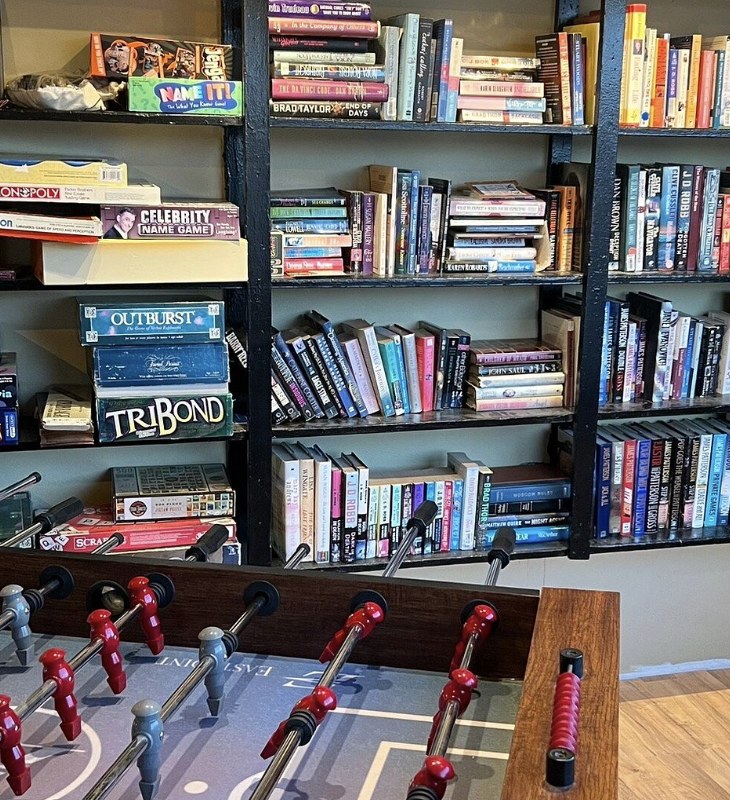 A lodge game room with a foosball table and shelves of books and board games near Boulder Utah