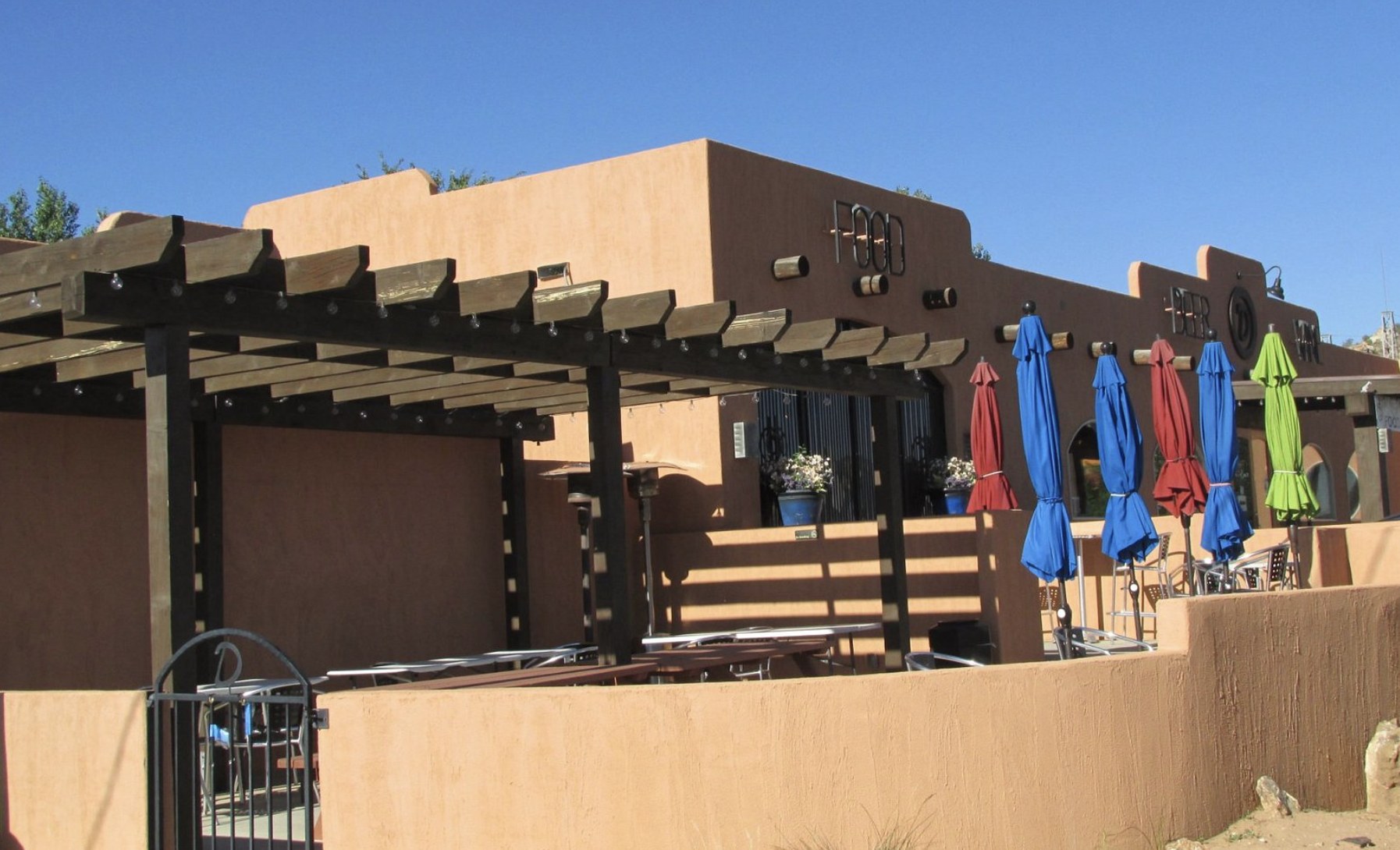Outdoor patio seating with colorful umbrellas at Circle D Eatery in Escalante during the day