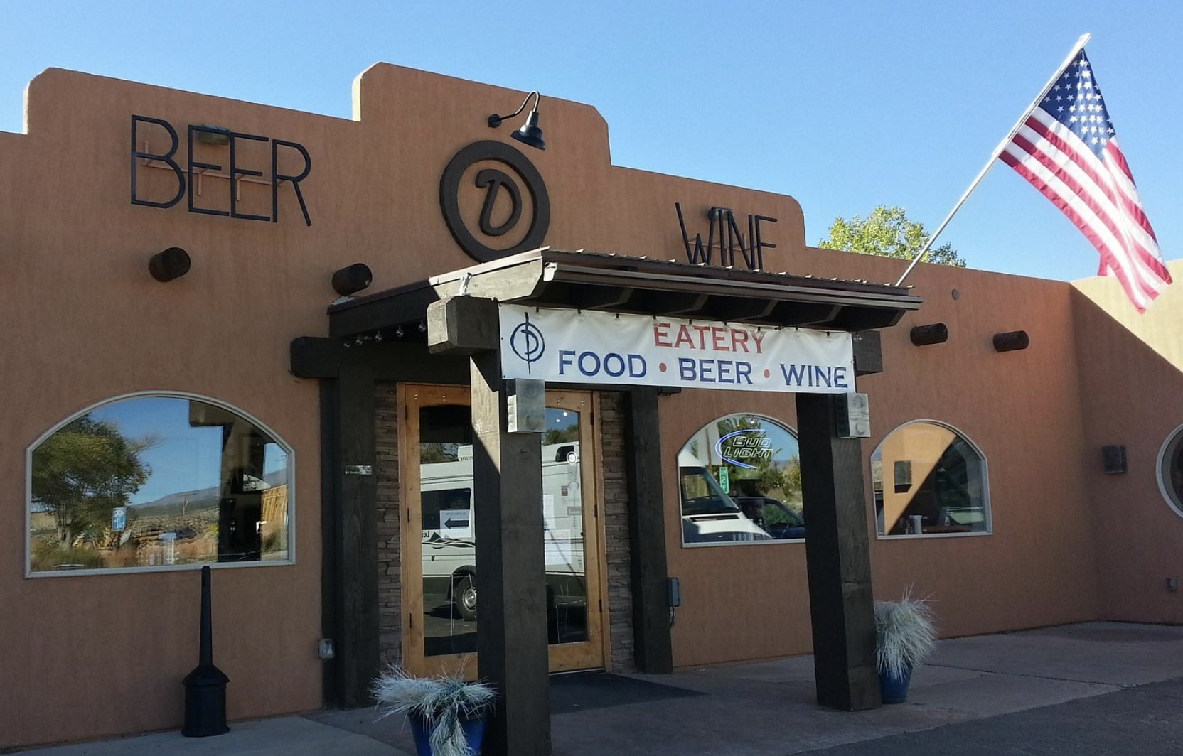 The Circle D Eatery storefront in Escalante Utah with a food beer and wine sign and an American flag