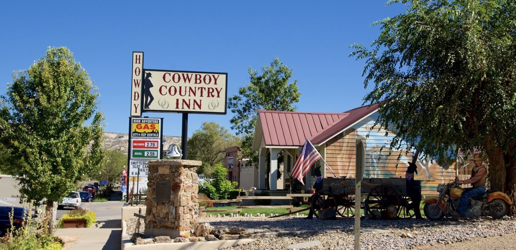 Howdy Cowboy Country Inn motel sign with gas prices and ATV and Jeep rental listings in Escalante Utah