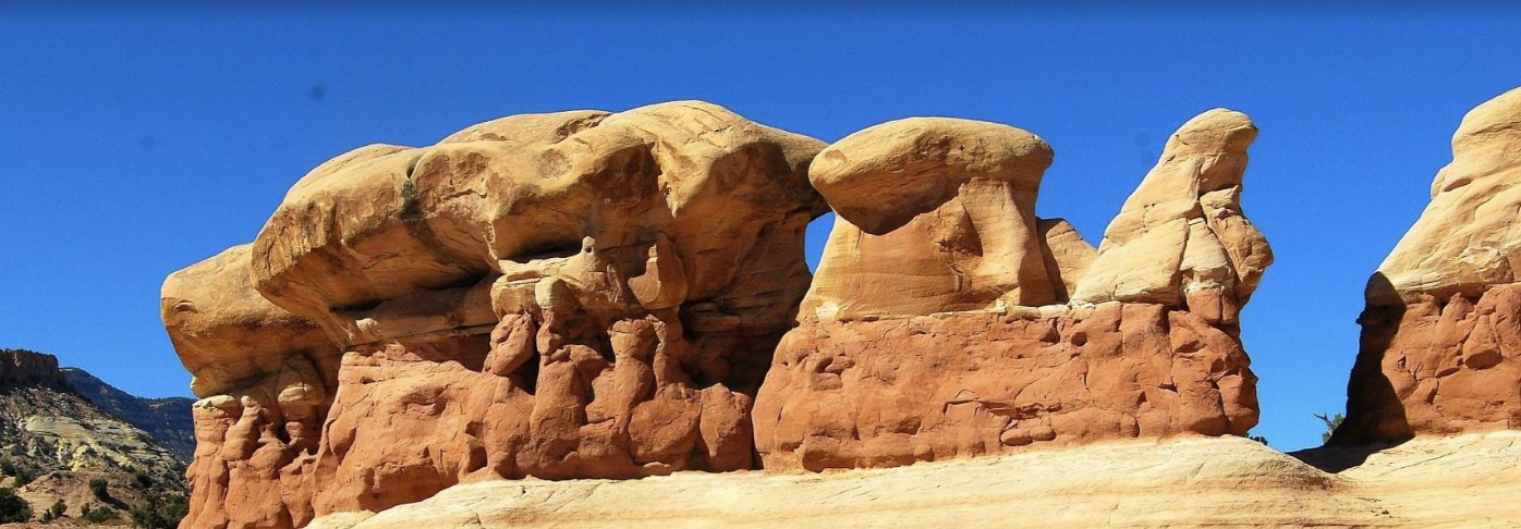A close up view of layered sandstone hoodoos and a small arch at Devils Garden near Escalante