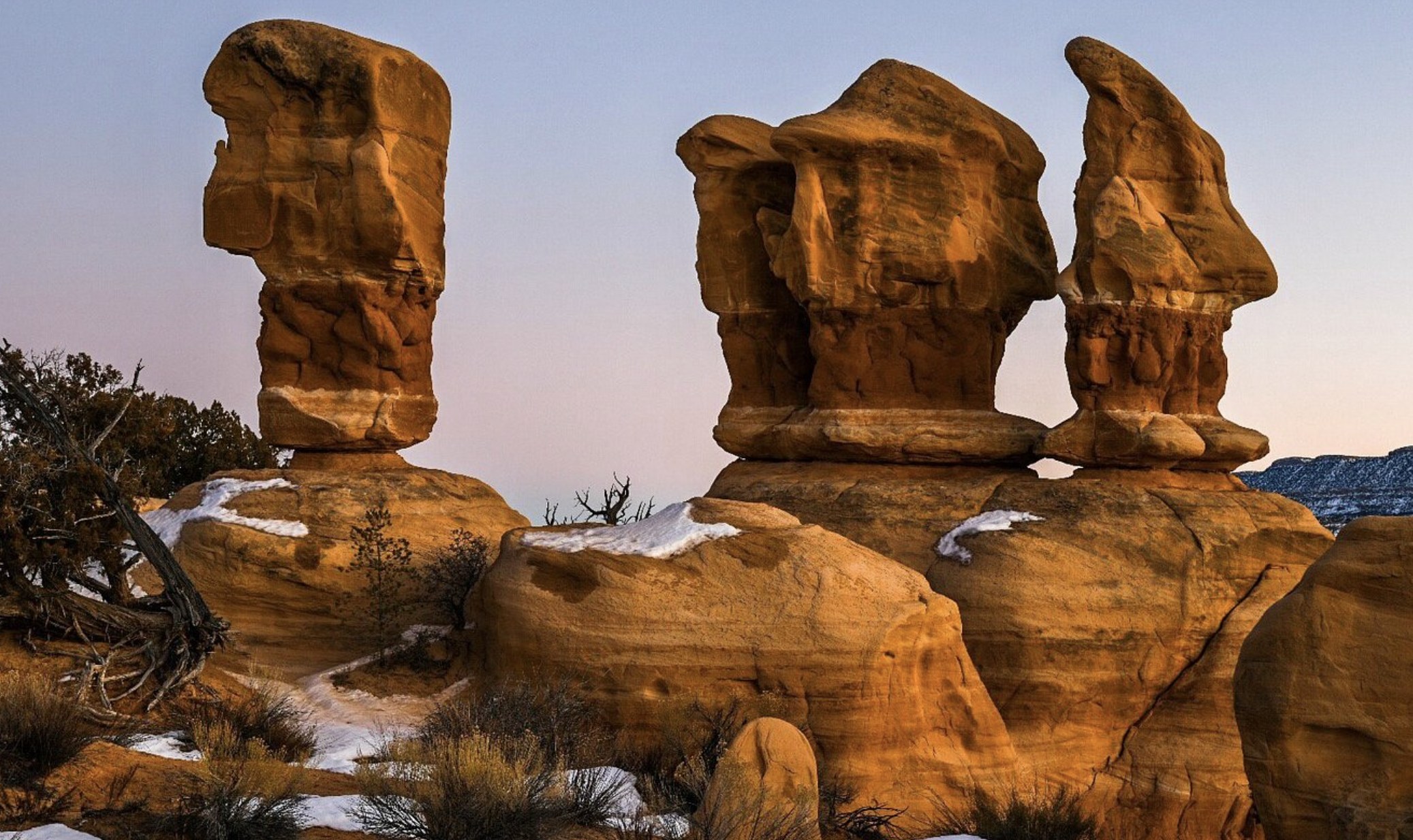Sandstone hoodoos dusted with snow glowing at sunset at Devils Garden near Escalante