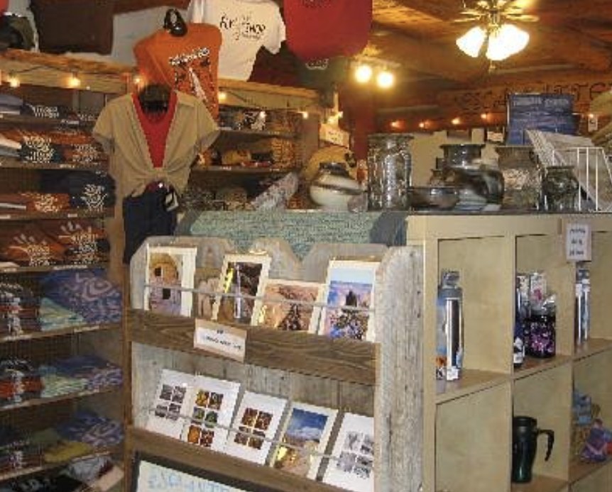 Gift shop interior with shirts, postcards, and pottery for sale in Escalante