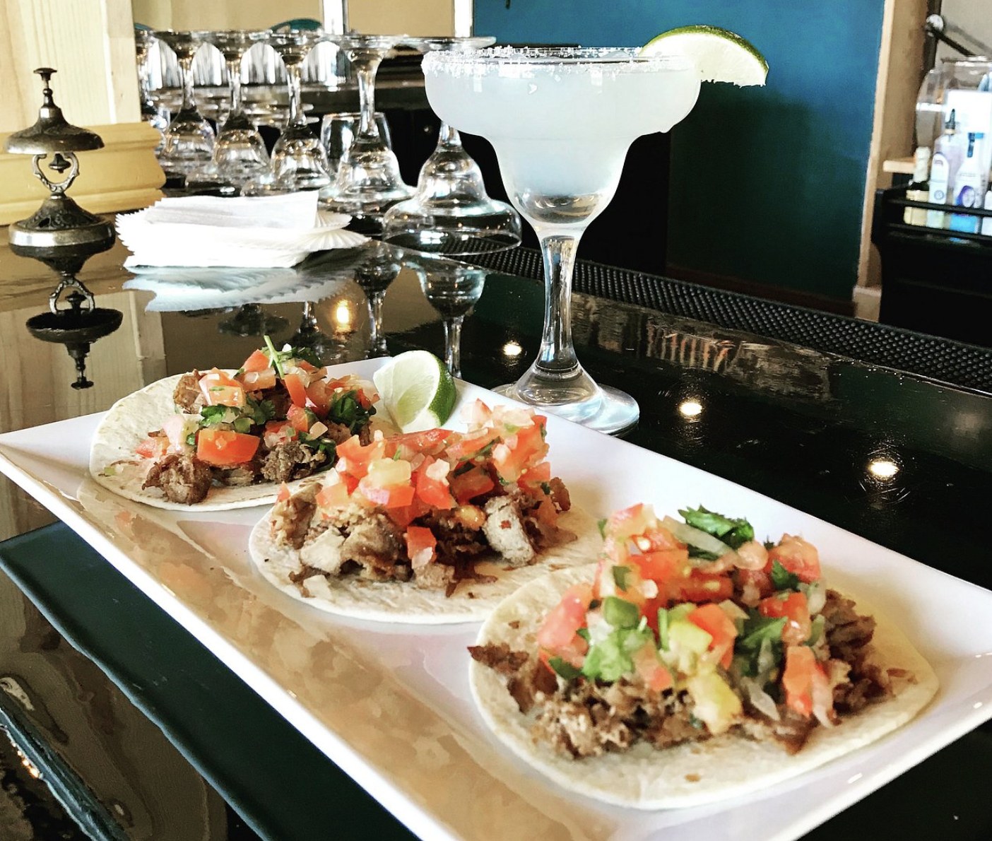 Three tacos with pico de gallo and a margarita served at a bar in Escalante