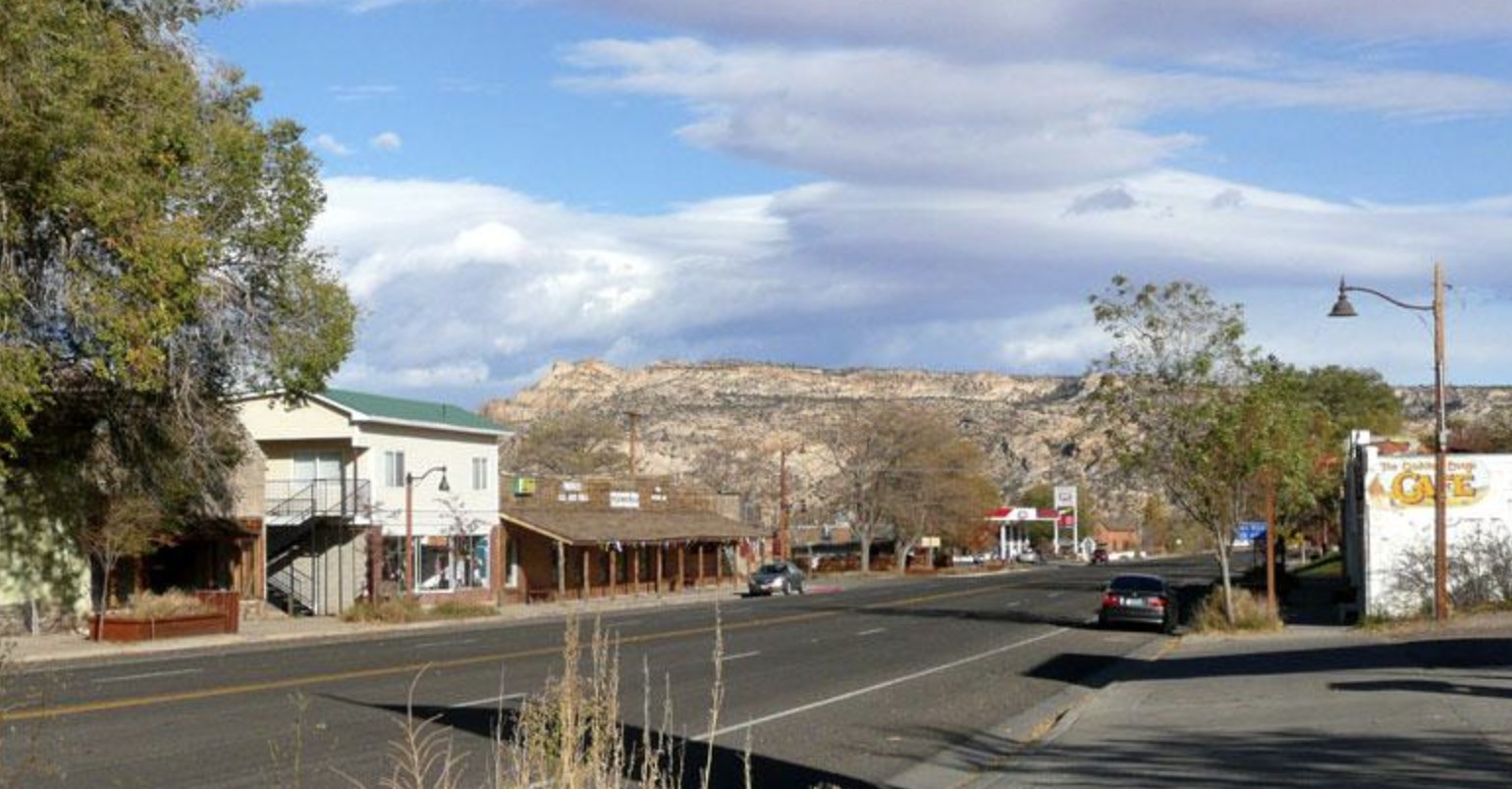 Main Street in Escalante Utah with local shops, a cafe, and the surrounding cliffs