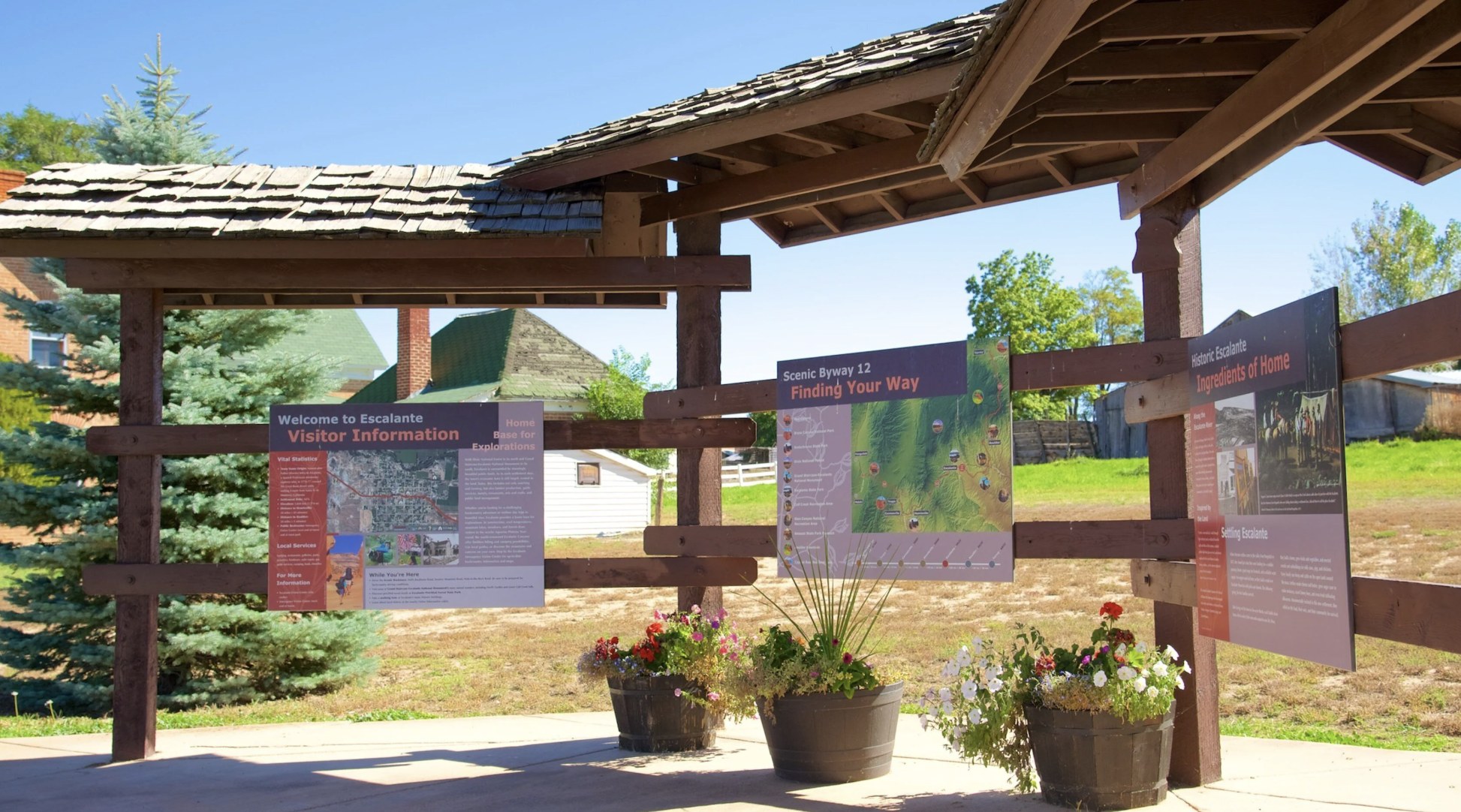 Outdoor visitor information kiosk in Escalante Utah with a Scenic Byway 12 map and area history panels