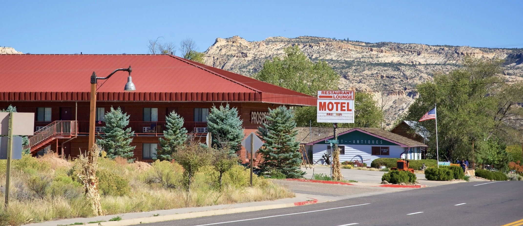 Prospector Inn motel building with a red roof in Escalante Utah, restaurant and lounge sign out front